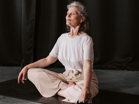 Frau meditiert auf einer Yogamatte