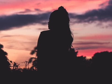 Frau mit Zopf und Dämmerung im Hintgergrund