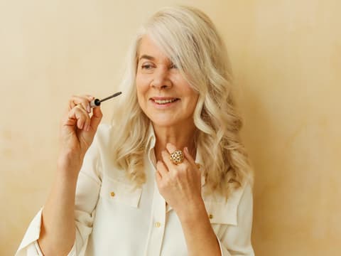 Frau traegt Mascara auf