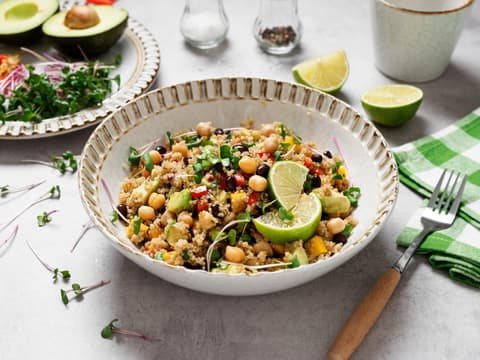 Ein Teller Quinoa-Salat mit Kichererbsen und Limette steht auf einem Tisch