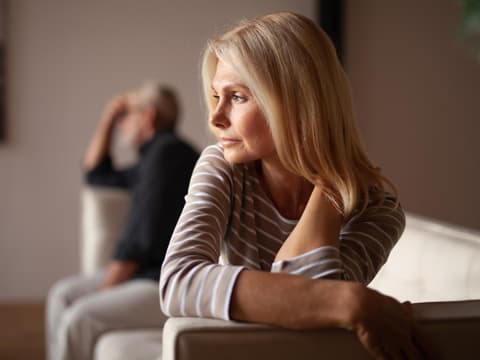 Mann und Frau sitzen nach einem Streit auf einer Couch