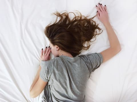Frau schläft auf Matratze Frau schläft auf Matratze