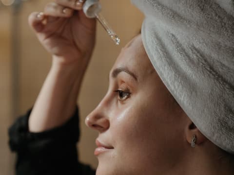 Frau trägt Gesichtsöl auf