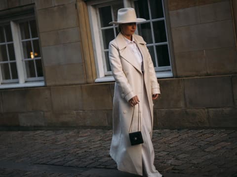 Frau auf Copenhagen Fashion Week trägt cremefarbenen Mantel Streetstyle