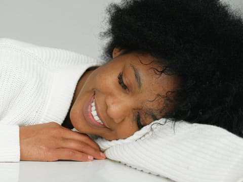 Glückliche Frau im weißen Pullover