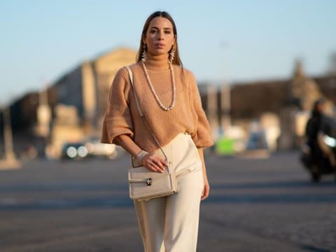 Frau trägt beigefarbene Handtasche