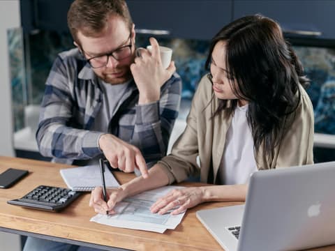 Mann und Frau gehen Rechnungen am Tisch durch