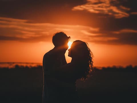 Für welche Sternzeichen es zum Ende des Monats noch richtig romantisch wird, liest du hier. Paar im Sonnenuntergang