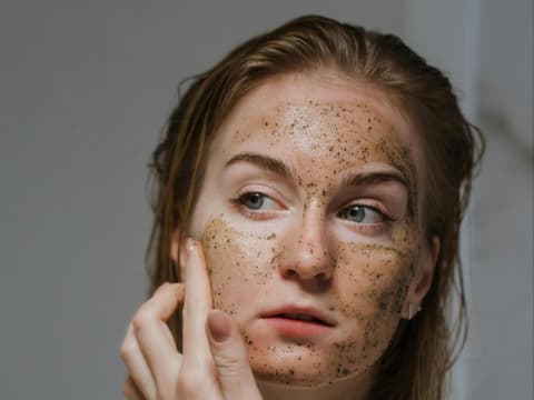 Green Peel Gesichtsmaske Frau trägt Green Peel Gesichtsmaske auf