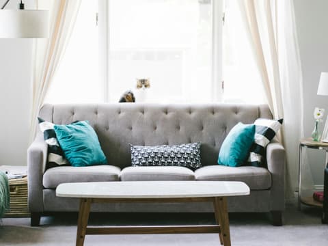 Grauer Sofa mit türkisen Kissen