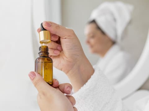 Frau hält Körperöl nach dem Duschen