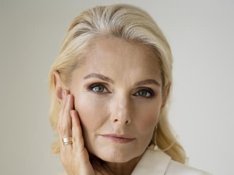 Dermaplaning ist der Hautpflege-Trend für einen glatten Teint. Frau fasst sich ins Gesicht