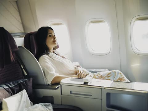 Frau in erster Klasse eines Flugzeuges