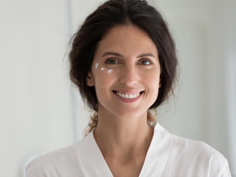 Welche Gesichtscreme für empfindliche Haut geeignet ist, liest du hier. Frau mit Creme im Gesicht