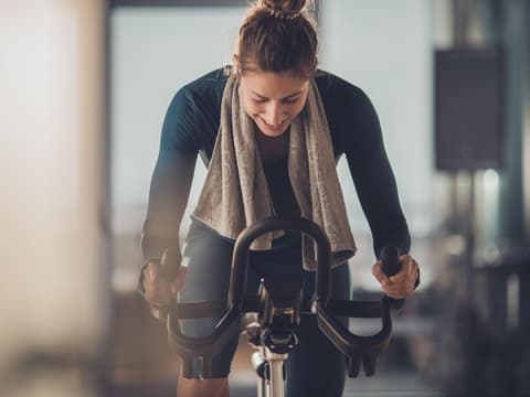 Spinning gilt als beliebte Trend-Sportart. Frau fährt auf einem Indoor-Fahrrad.