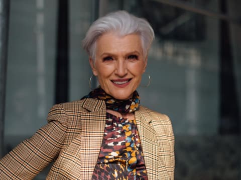 Maye Musk mit einem kurzen Haarschnitt und karierten Anzug.