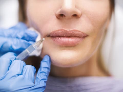 Frau lässt sich Lippen aufspritzen