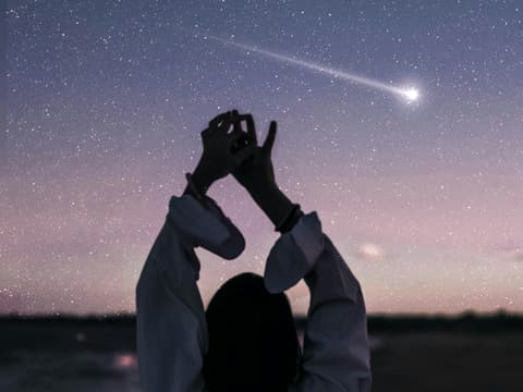 Frau steht vor Sternenhimmel