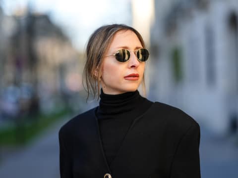 Straight Brows sind angesagter denn je. Frau mit Sonnenbrille und einem schwarzen Rollkragenshirt.