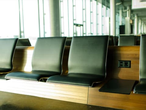 Sitzbänke mit schwarzen Polstern am Flughafen.
