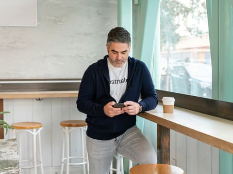 Mann am Handy im Cafe