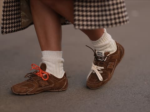 Das sind die Sneaker-Trends 2025. Frau in braunen Sneakern