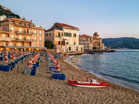 Strand von Cilento mit Häusern, Liegen und Sonnenschirmen.