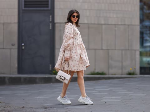 Frau in Kleid mit Sneaker