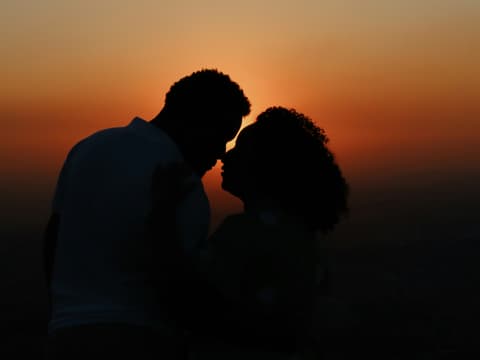 Was dein Sternzeichen in Sachen Romantik im Juni erwartet? Wir verraten es! Paar küsst sich vor Sonneuntergang