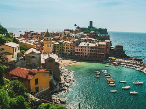 Vernazza in der Toskana ist definitiv einen Besuch wert. Die Küste von Vernazza in der Toskana mit bunten Häusern und Booten im Wasser.