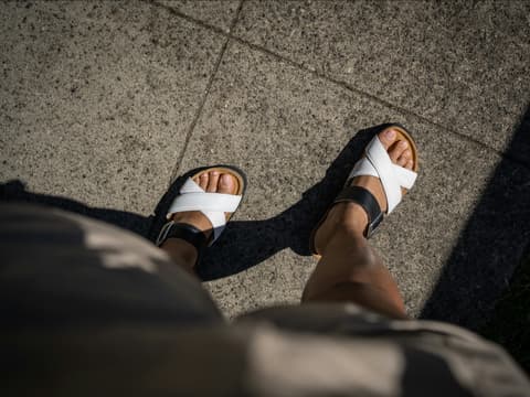 Dieses Produkt von dm verhindert die Entstehung von Blasen an den Füßen. Frauenfüße in Sandalen