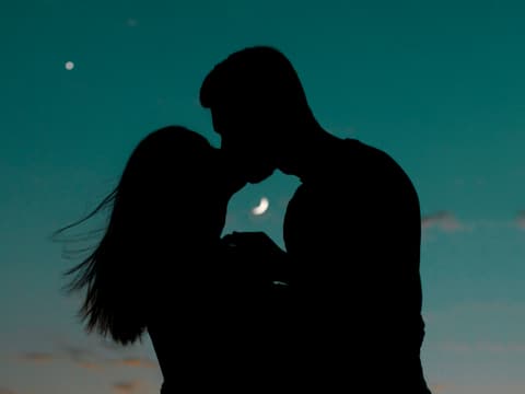 In unserem Liebeshoroskop für den Juli erfährst du, was deinem Sternzeichen in Sachen Romantik jetzt bevorsteht. Pärchen küsst sich vor Mondhimmel
