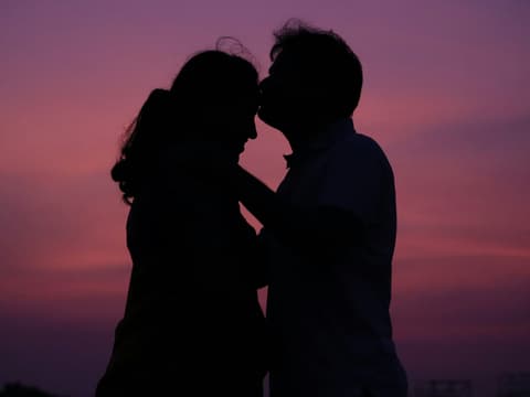 Paar vor pinkem Abendhimmel