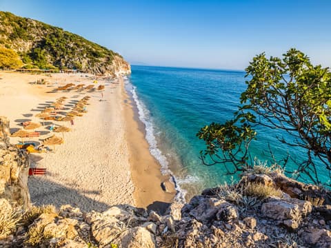 Himare in Albanien bietet tolle Urlaubsmöglichkeiten im Frühling. Ein Strand in Himare in Albanien mit türkisblauem Wasser und rauer Natur.