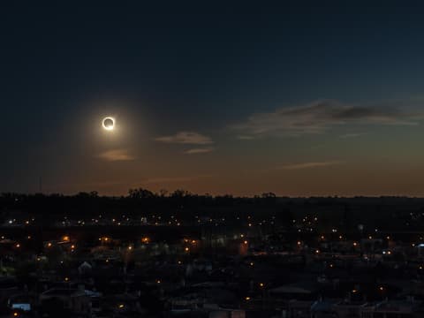 In diesem Jahr erleben wir eine totale Sonnenfinsternis im August. Totale Sonnenfinsternis über den Dächern einer Stadt.