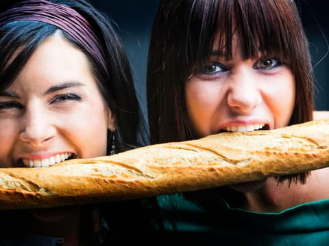 Junge Frauen beißen in Baguette