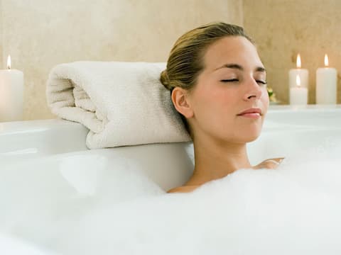 Eine Frau entspannt sich in der Badewanne Eine Frau entspannt sich in der Badewanne