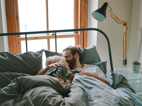 Paar kuschelt im Bett