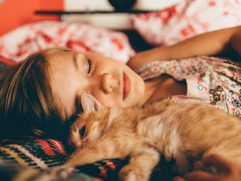 Katze schläft neben Mädchen