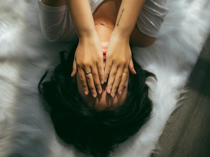 Frau hält sich die Hände vor das Gesicht