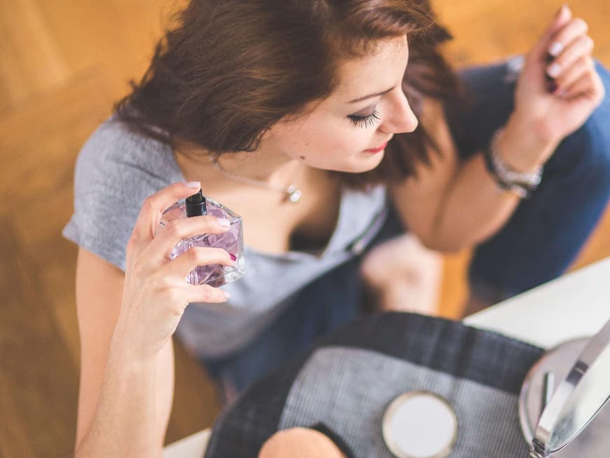 Frau mit Parfum in der Hand