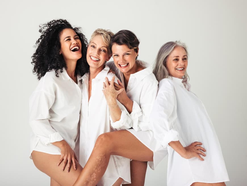 Vier ältere Frauen lachen zusammen.