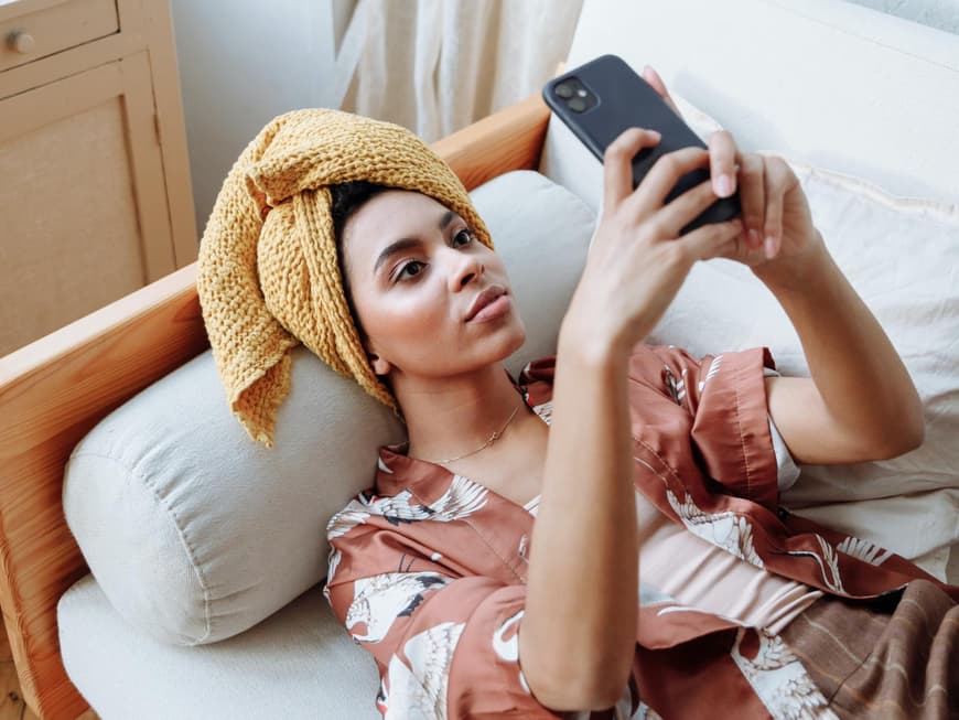 Frau mit Handy auf Sofa
