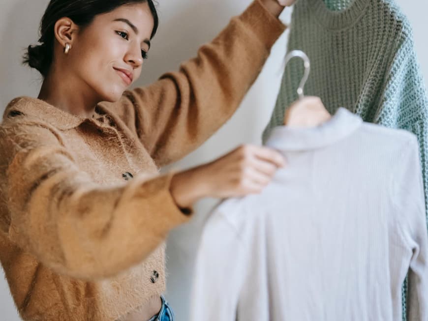 Frau mit Kleidung auf Kleiderbügel