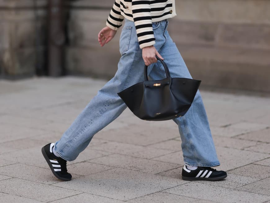 Frau trägt Adidas Sneaker und Jeans