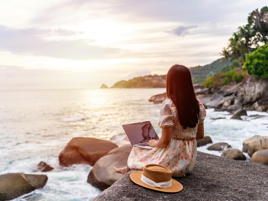 Frau mit Laptop am Strand