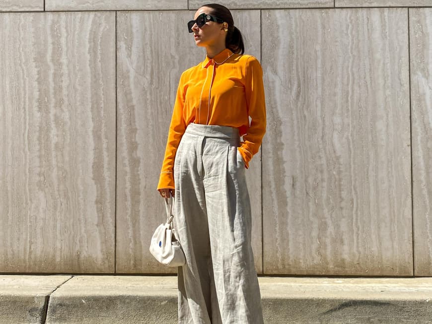 Dieses Outfit lieben alle Französinnen im Sommer Frau trägt ein Outfit aus weißter Palazzohose und Bluse