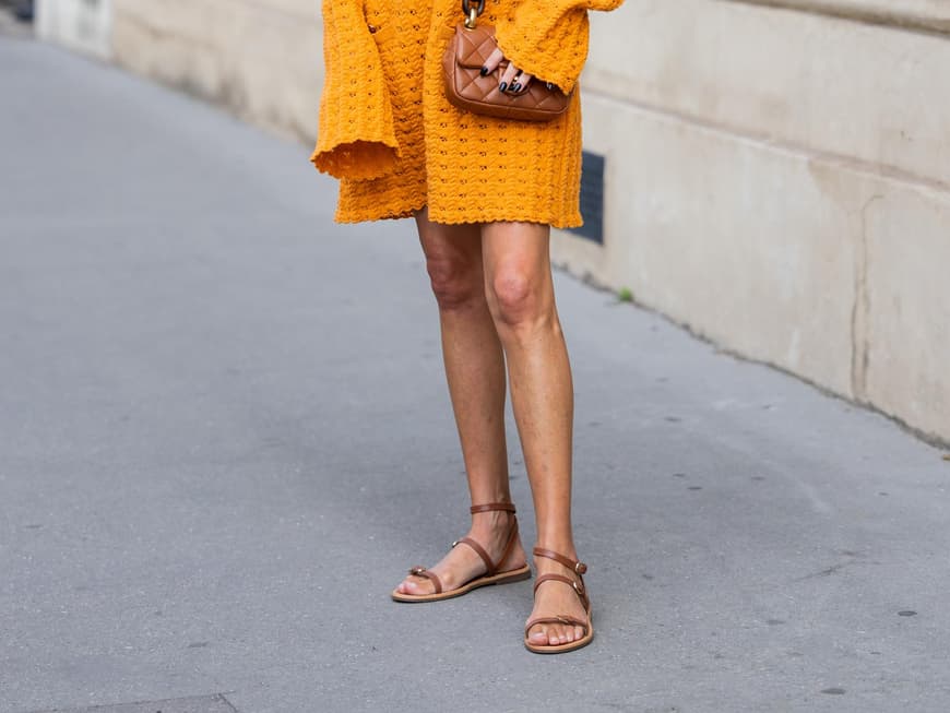 Dieses Midi-Kleid passt perfekt zu braunen Sandalen Frau in orangenem Midikleid