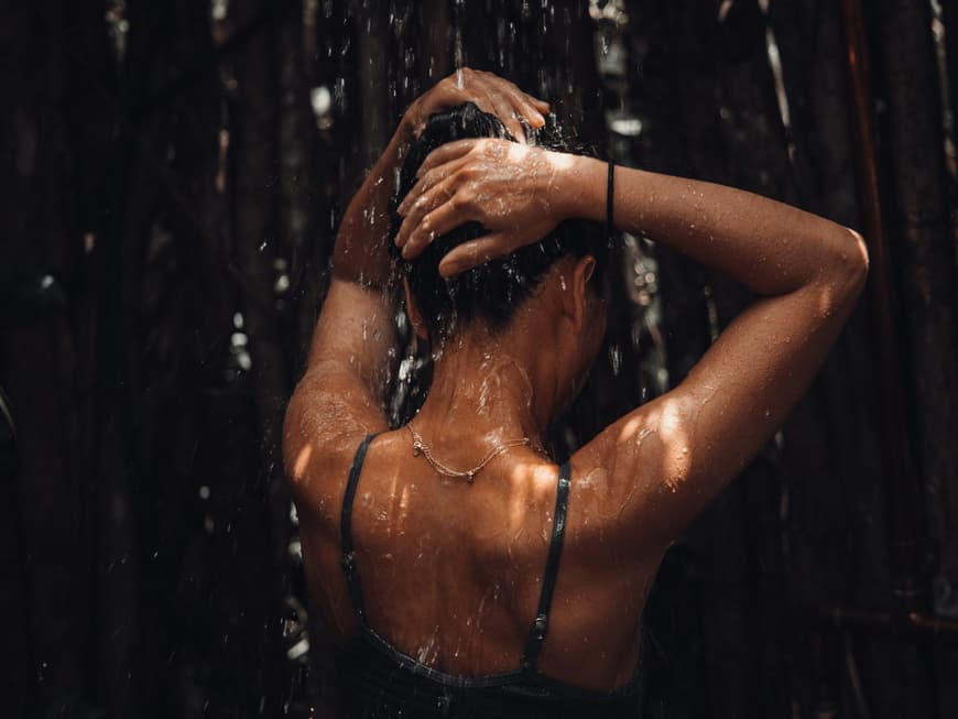 Frau im Bikini unter der Dusche