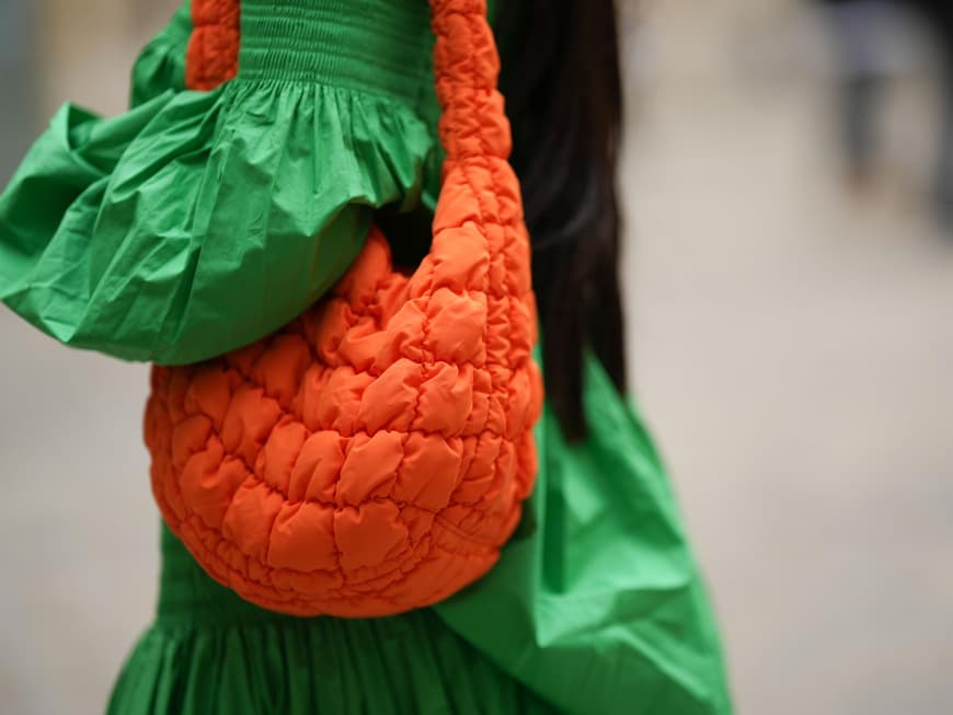 Eine Frau trägt eine große Tasche von COS